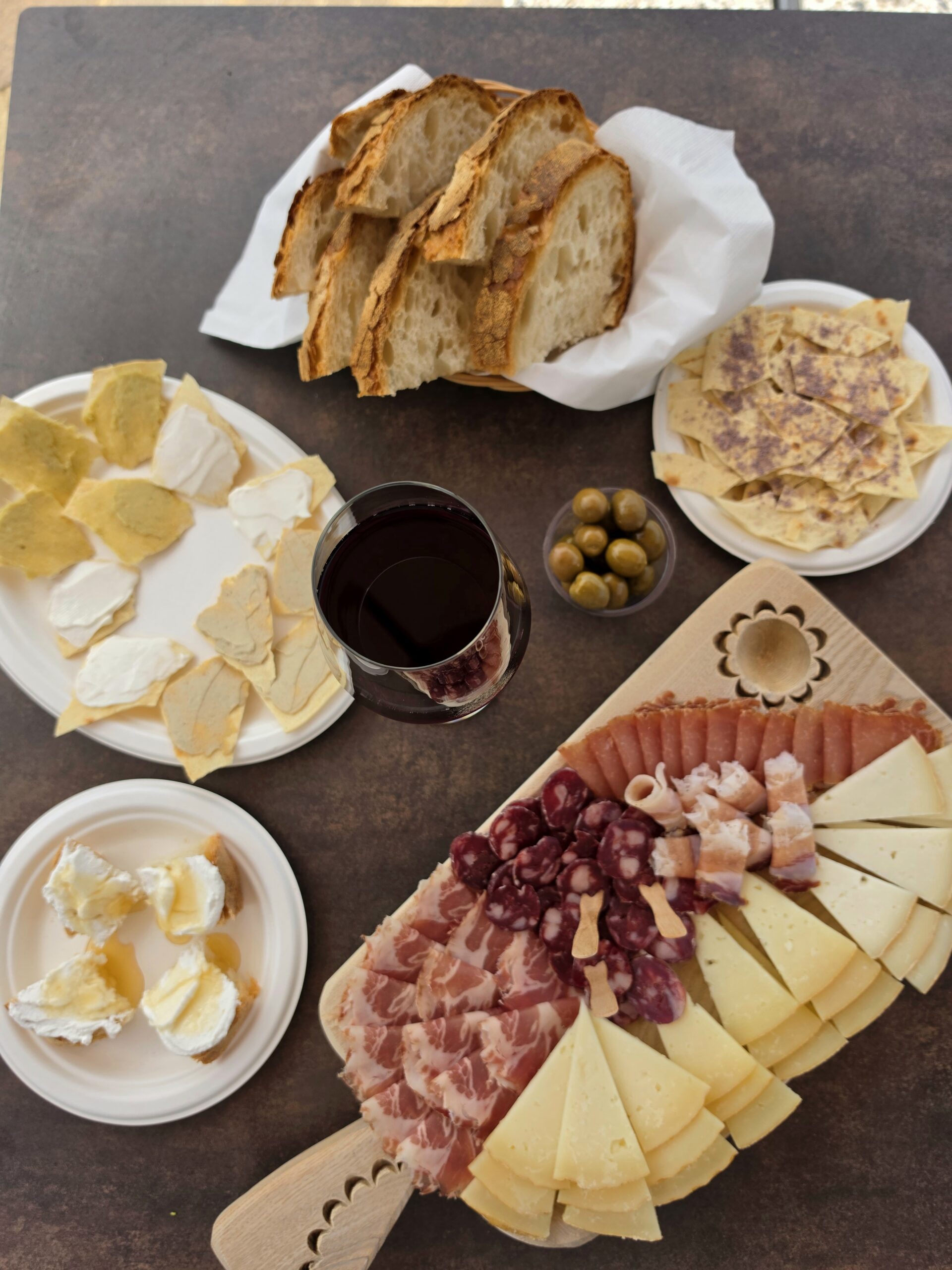 Il tavolo del Menù Tagliere visto dall'alto: pane, olive e prodotti tipici